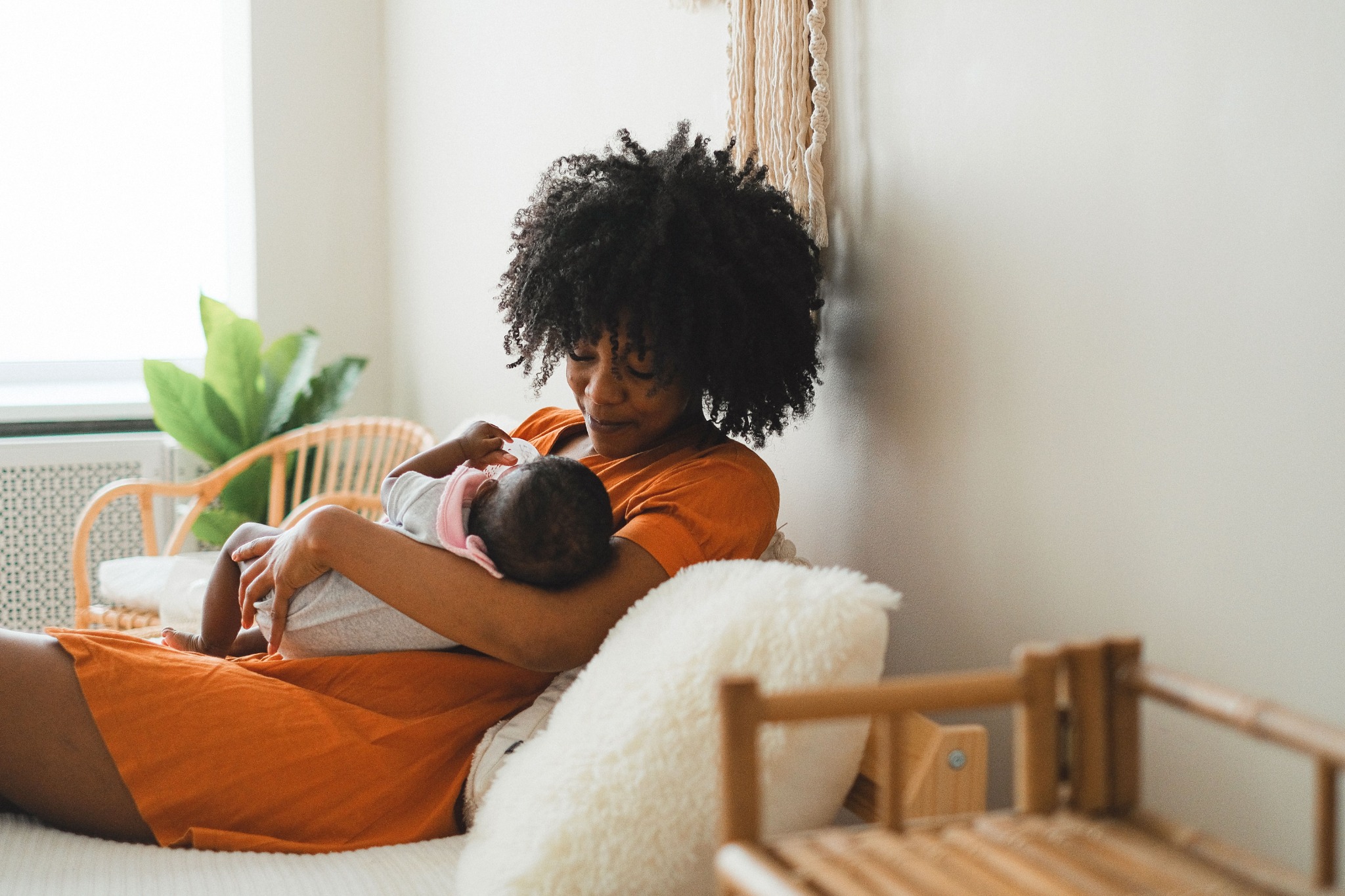 Mother holding her newborn baby at home